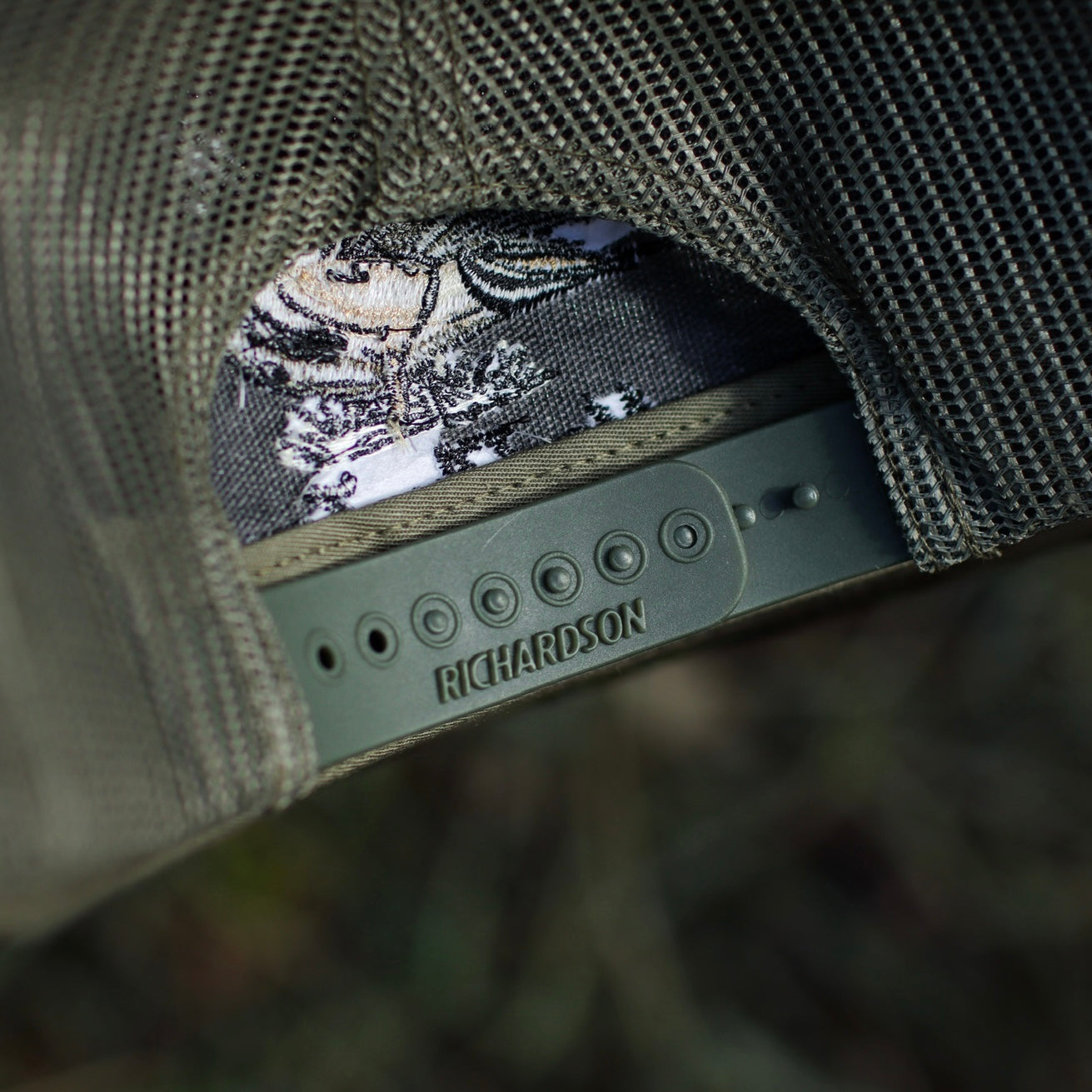 Close-up of a Richardson cap with embroidered design on a blurred background
