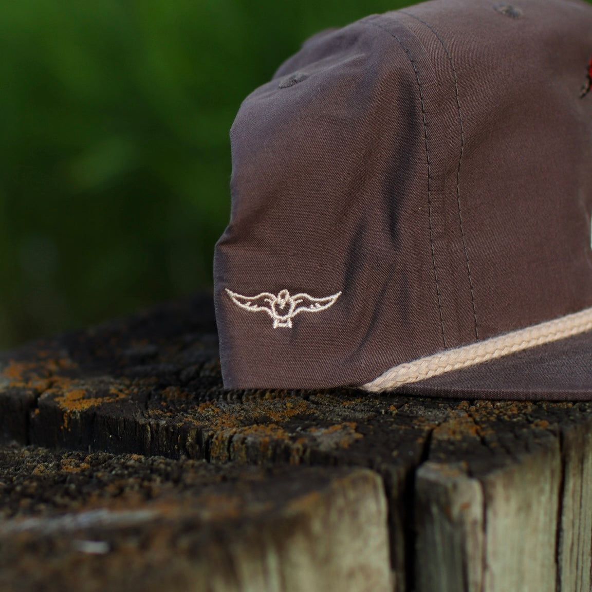 Brown rope hat with no fly zone logo on a wooden surface